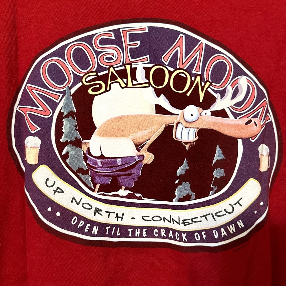Moose Moon Saloon. Small logo on front. Large one on back. Color is a deep red.